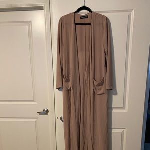 Naked Wardrobe sheer nude duster with two large pockets.